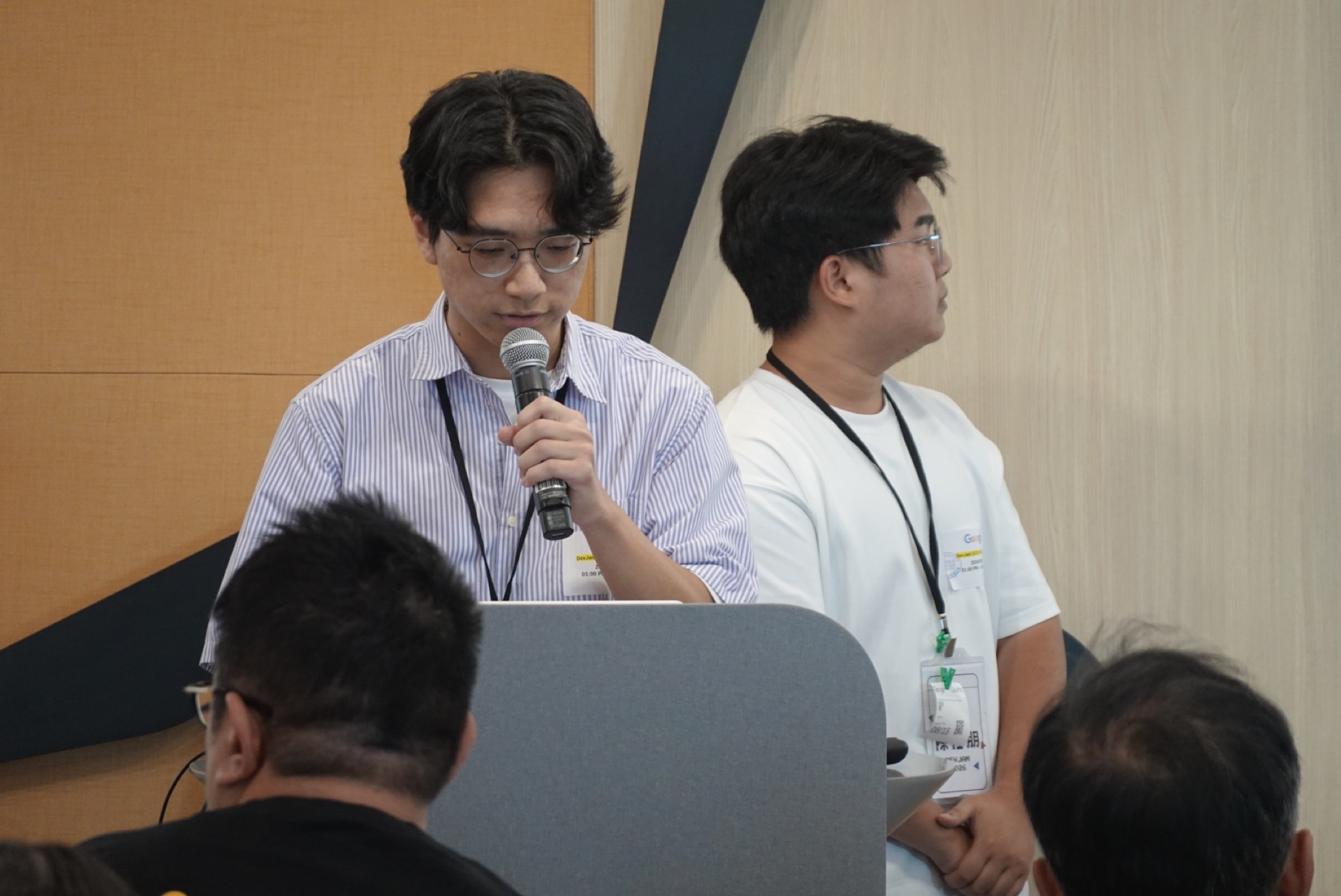 參賽者站在講台前拿著麥克風發表