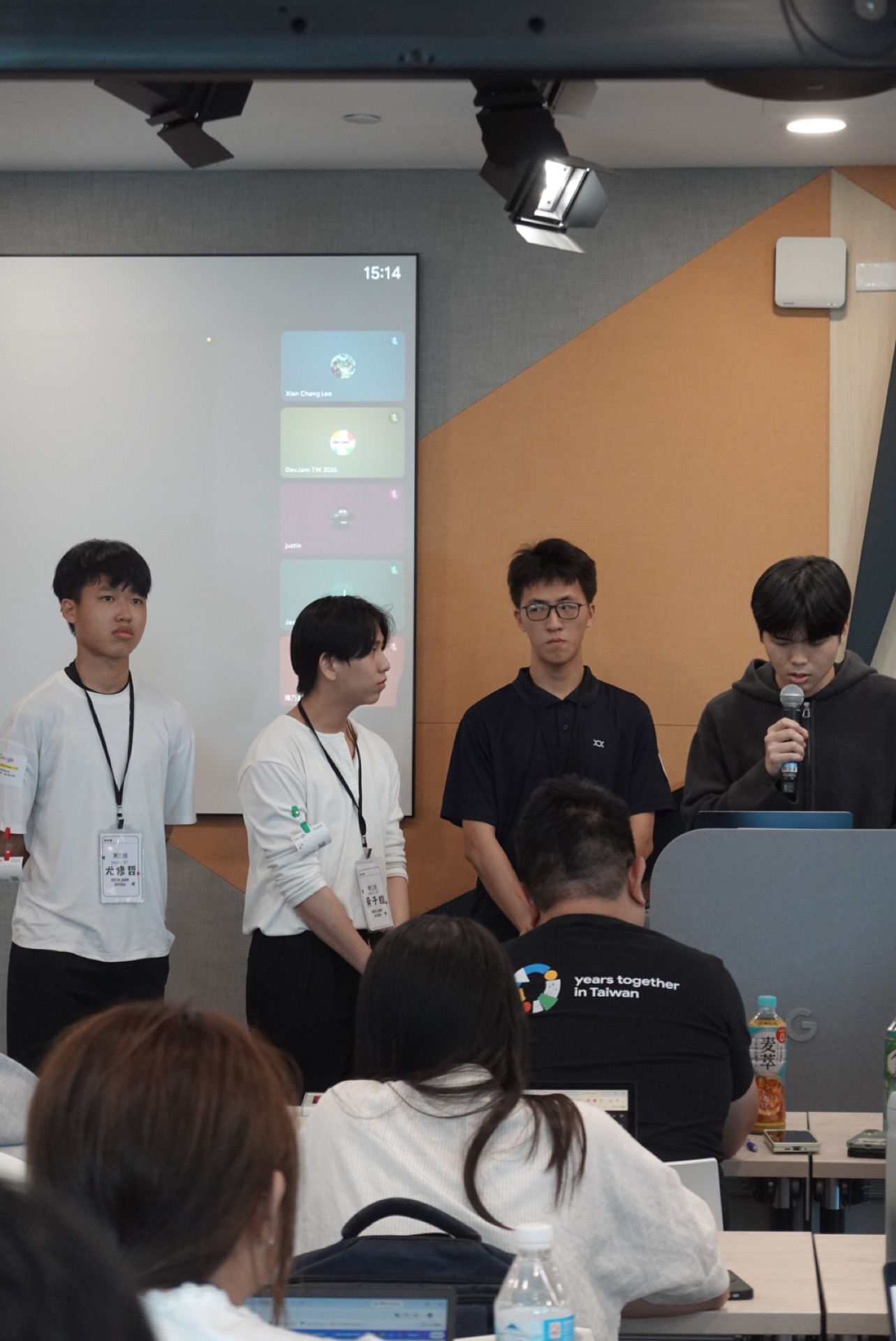 四位組員站在螢幕前接受提問